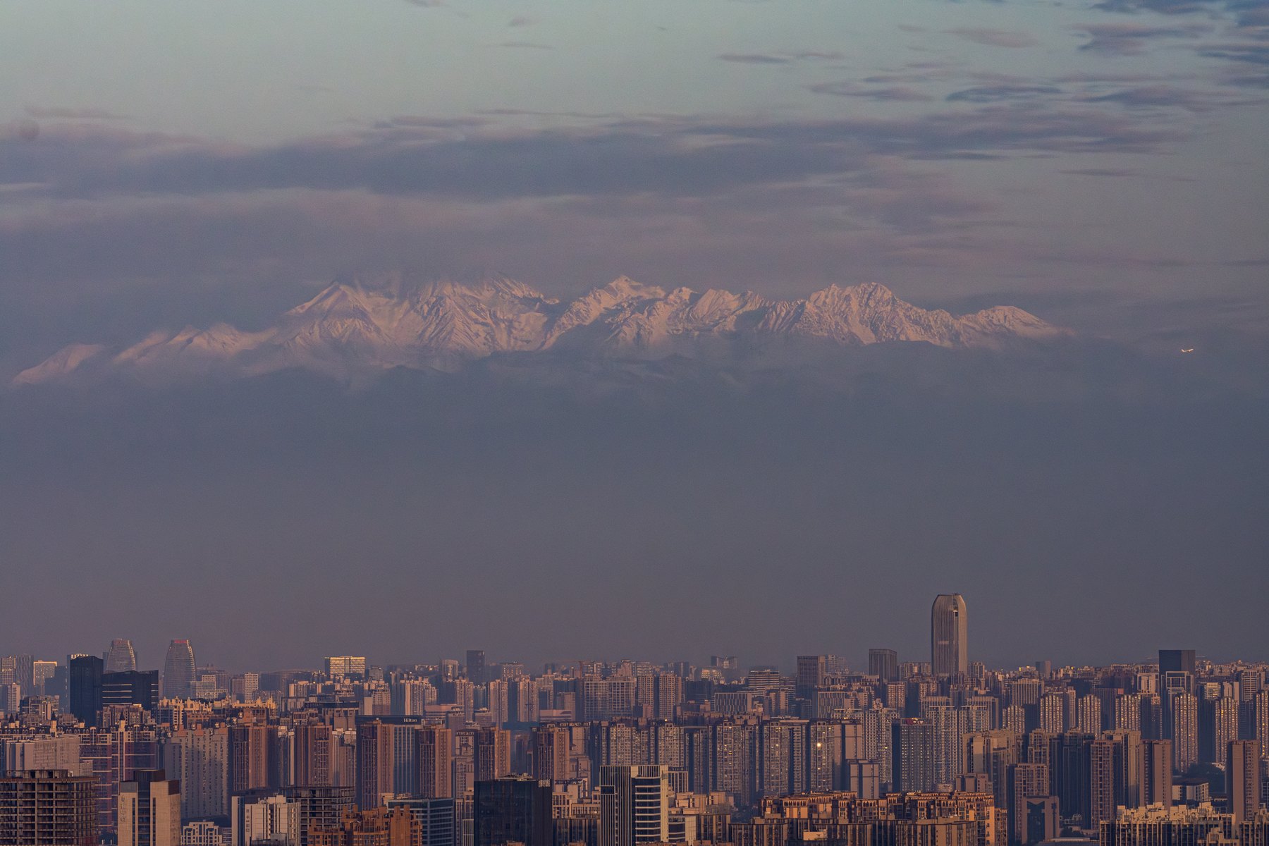 龙泉山日出：成都城市天际线与远处的雪山